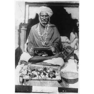  A Pundit in India,man seated with legs crossed,reading a 