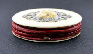 Genuine red leather is sandwiched between 2 oval pieces of a natural 